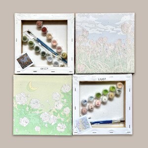 May include: Four paint by numbers kits featuring different designs. Each kit includes a canvas, paints, and brushes. The designs include a moon and flowers, a field of flowers, a field of flowers, and a field of flowers. The kits are labelled with the numbers 62140, LIU07, and LIU07.