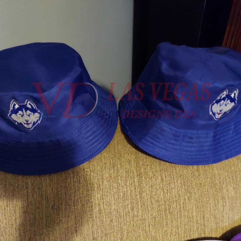 Custom hat logo digitized embroidery showing detailed husky mascot design on blue bucket hats, created for professional logo digitizing, hat embroidery digitize, and brand image stitching by Las Vegas Designs USA.