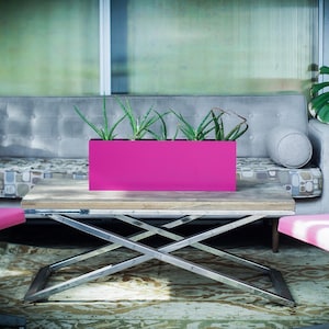 May include: A modern outdoor living space featuring a gray sofa, two pink chairs, and a wooden coffee table with a bright pink rectangular planter box filled with green plants. The space has a relaxed, contemporary vibe.