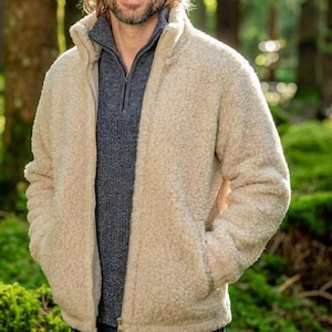 Male model wearing oatmeal merino wool jacket outdoors showing styling and fit on woodland background