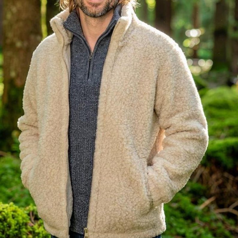 Male model wearing oatmeal merino wool jacket outdoors showing styling and fit on woodland background