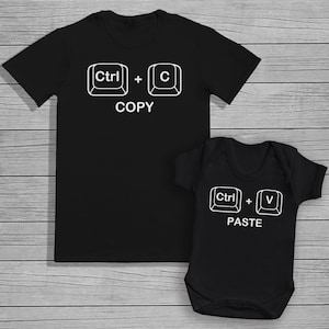 May include: Black t-shirt with white text that reads "Ctrl + C COPY" and a black baby onesie with white text that reads "Ctrl + V PASTE".