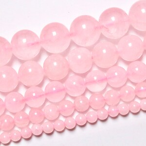 May include: A strand of pink rose quartz beads in various sizes. The beads are round and smooth, with a translucent appearance.