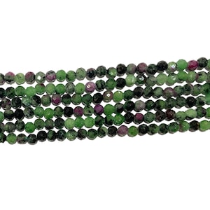Peut inclure: Un brin de perles de pierres précieuses facettées vertes, roses et noires. Les perles sont rondes et ont une finition lisse et polie.