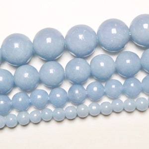 Peut inclure: Un brin de perles de pierres précieuses bleu clair de différentes tailles. Les perles sont rondes et lisses, et elles sont disposées en un motif gradué, avec les plus grosses perles en haut et les plus petites en bas.