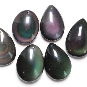 Peut inclure: Six pendentifs en obsidienne en forme de goutte avec des couleurs arc-en-ciel irisées. Les pendentifs ont un trou en haut pour la ficelle.