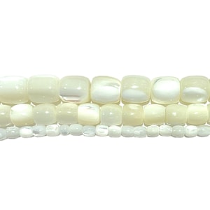 以下が含まれることがあります： 3つの異なるサイズで構成された白い貝殻ビーズのストランド。ビーズは滑らかで、わずかに虹色の光沢があります。