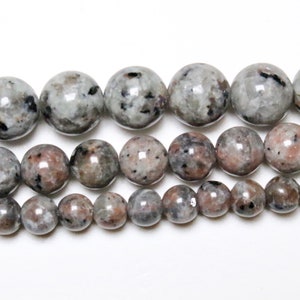 Peut inclure: Un brin de perles rondes, mouchetées de gris et de noir. Les perles sont de tailles différentes, les plus grandes mesurant environ 2,5 cm de diamètre.