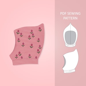 Può includere: Un cappello rosa con cappuccio e un motivo floreale. Il cappello è realizzato in un tessuto morbido e lavorato a maglia e ha un design semplice. Il motivo presenta piccoli fiori rosa con steli verdi.