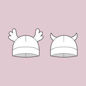 Puede incluir: Dos gorros de punto blanco con diseños diferentes. Un gorro tiene dos pequeñas astas en la parte superior, y el otro tiene dos pequeñas astas de ciervo en la parte superior.