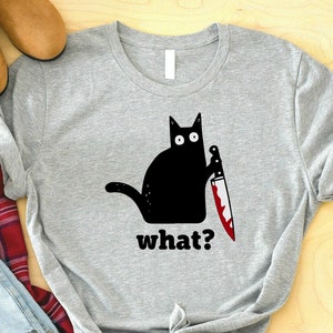 May include: Gray t-shirt with a black cat holding a bloody knife and the text "what?"