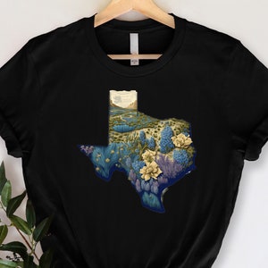 May include: Black t-shirt with a graphic of the state of Texas filled with bluebonnets and other wildflowers.