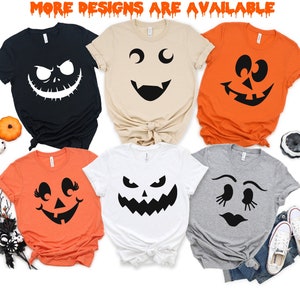 May include: Six different t-shirts with various jack-o'-lantern faces printed on them. The shirts are in different colors, including black, orange, white, tan, and gray.