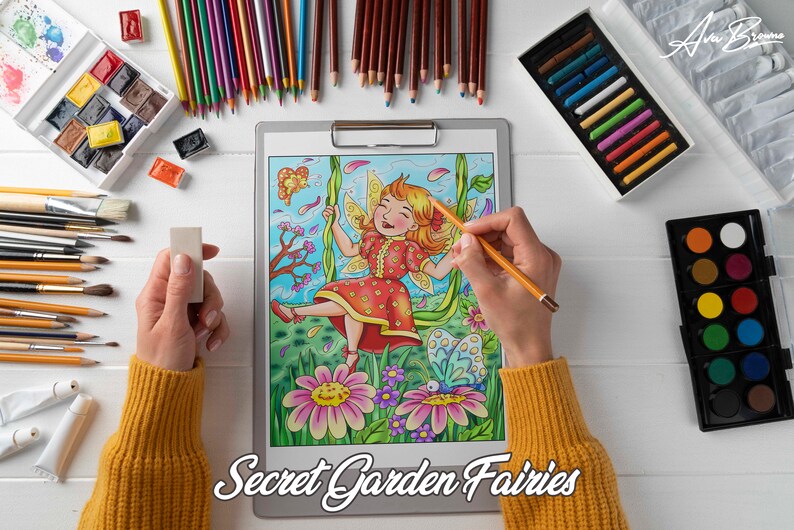 K&ouml;nnte beinhalten: Eine Person f&auml;rbt eine detaillierte Illustration einer Fee auf einer Schaukel in einem Garten mit Blumen und Schmetterlingen. Die Illustration tr&auml;gt den Titel "Secret Garden Fairies". Die Person verwendet farbige Bleistifte und einen Radiergummi.