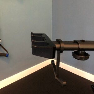 May include: Black metal weight plate holder with three slots. The holder is mounted on a black metal stand with a knob for adjusting the height.