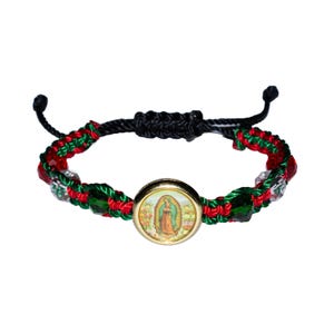May include: A woven bracelet featuring a central gold-toned medallion with an image of the Virgin Mary. The bracelet incorporates red, green, and clear beads, with a black adjustable cord closure. The bracelet is a religious accessory.