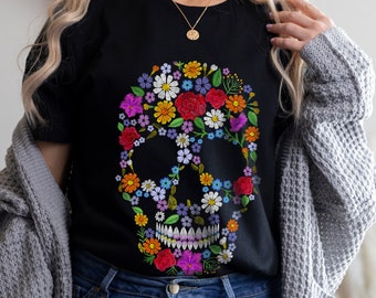 Könnte beinhalten: Schwarzes T-Shirt mit einem farbenfrohen Blumenschädel-Design. Der Schädel besteht aus verschiedenen Blumen in den Farben Rosa, Lila, Gelb, Rot und Blau.