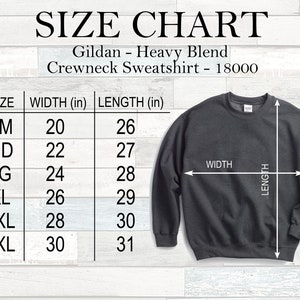 May include: A size chart for a Gildan Heavy Blend crewneck sweatshirt. The chart lists sizes SM to 3XL, with corresponding width and length measurements in inches. A dark grey sweatshirt is shown with width and length indicators.