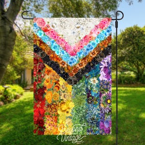 a colorful quilt hanging from a metal pole