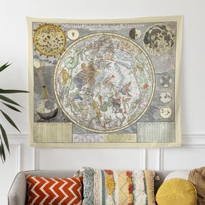 a couch with pillows and a tapestry hanging on the wall