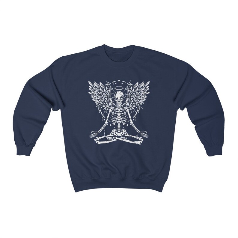 May include: Navy blue sweatshirt with a white graphic of a skeleton angel in a yoga pose. The design includes a halo and geometric shapes. The sweatshirt is made of a soft, comfortable material.