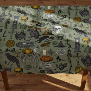 Puede incluir: Un mantel verde con un patrón repetido de ilustraciones de Halloween. El diseño incluye calabazas, calaveras, murciélagos, cuervos y otros elementos espeluznantes en negro, blanco y amarillo.