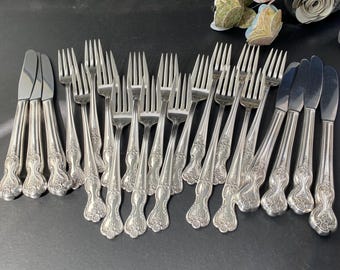 Puede incluir: Un juego de cubiertos vintage, que incluye tenedores y cuchillos, con diseños ornamentados. Los cubiertos están hechos de plata y tienen un acabado pulido.