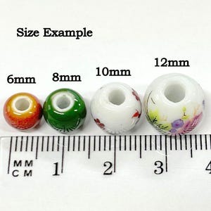 K&ouml;nnte beinhalten: Gr&ouml;&szlig;enbeispiel f&uuml;r vier Keramikperlen mit Blumendesigns. Die Perlen haben einen Durchmesser von 6 mm, 8 mm, 10 mm und 12 mm.