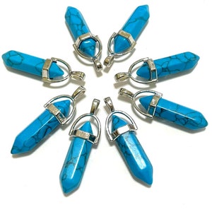 May include: Eight turquoise gemstone pendants with silver settings. Each pendant is shaped like a pointed crystal and has a silver loop for attaching to a chain or cord.