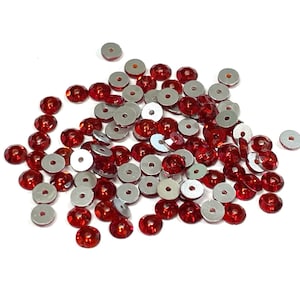 May include: A pile of red and silver sequins. The sequins are round and have a flat back. They are perfect for adding sparkle to crafts and clothing.