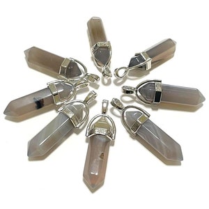 May include: Seven grey agate crystal pendants with silver-toned metal bails. The pendants are in the shape of a point, with a smooth, polished surface.