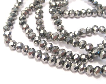 May include: A strand of silver-toned faceted glass beads. The beads are round and have a faceted, diamond-like appearance.