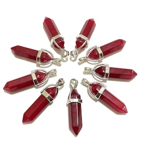 May include: Eight red gemstone point pendants with silver-toned metal settings. The pendants are arranged in a circle on a white background.