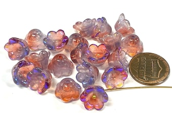 May include: A collection of 17 iridescent glass flower beads in shades of pink and purple. The beads have a slightly textured surface and are approximately 1 inch in diameter.