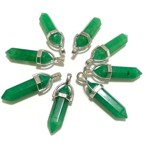 May include: Eight green crystal point pendants with silver settings. The pendants are arranged in a circle on a white background.