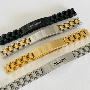May include: Four different metal bracelets with engraved nameplates. The bracelets are silver, gold, black, and silver with a gold band. The nameplates are engraved with the text "III-VI-MMII" and "Jordan".