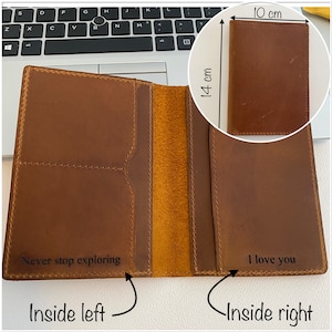 Puede incluir: Una cartera de cuero marr&oacute;n con dos compartimentos. El compartimento izquierdo tiene el texto "Never stop exploring" y el compartimento derecho tiene el texto "I love you". La cartera mide 10 cm de ancho y 14 cm de alto.