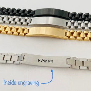 May include: A silver bracelet with a rectangular tag that reads "I.V.MMII" engraved on the inside. The bracelet is made of a chain link design.