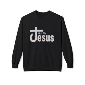 Puede incluir: Sudadera negra de cuello redondo con el texto "Got Me Jesus" en una fuente blanca estilizada. El diseño incluye una cruz incorporada en la palabra "Jesus". La sudadera es de color negro liso.