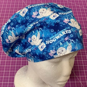May include: Blue and white surgical scrub hat with a Hogwarts theme. The hat features a repeating pattern of owls, envelopes, and the words "Waiting for my letter from Hogwarts".