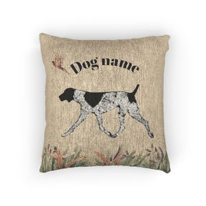 May include: Square throw pillow with a textured beige background. A running dog illustration with black and white markings is centered, with the text "Dog name" above. Decorative foliage is at the bottom, and a small bird graphic is at the top left.