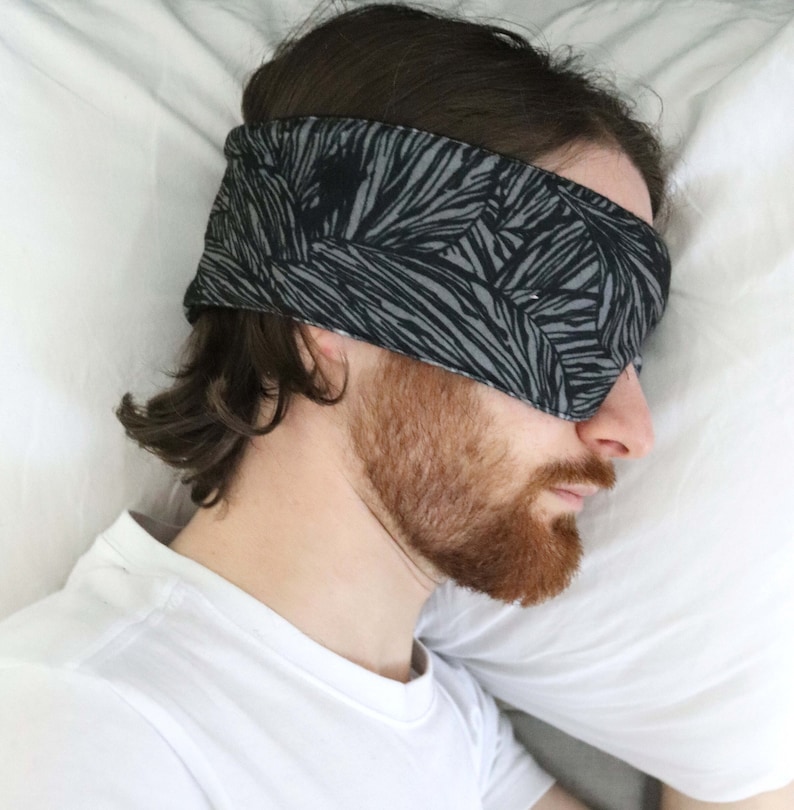 guy sleeping on his side with an eye mask