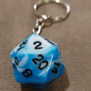 May include: A blue and white marbled 20-sided die with black numbers on each side. The die is attached to a silver keychain.