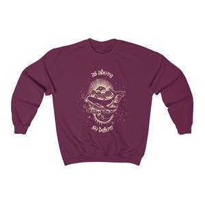 May include: Burgundy sweatshirt with a graphic of a whale swimming in clouds with the text "as above so below" in a vintage font.