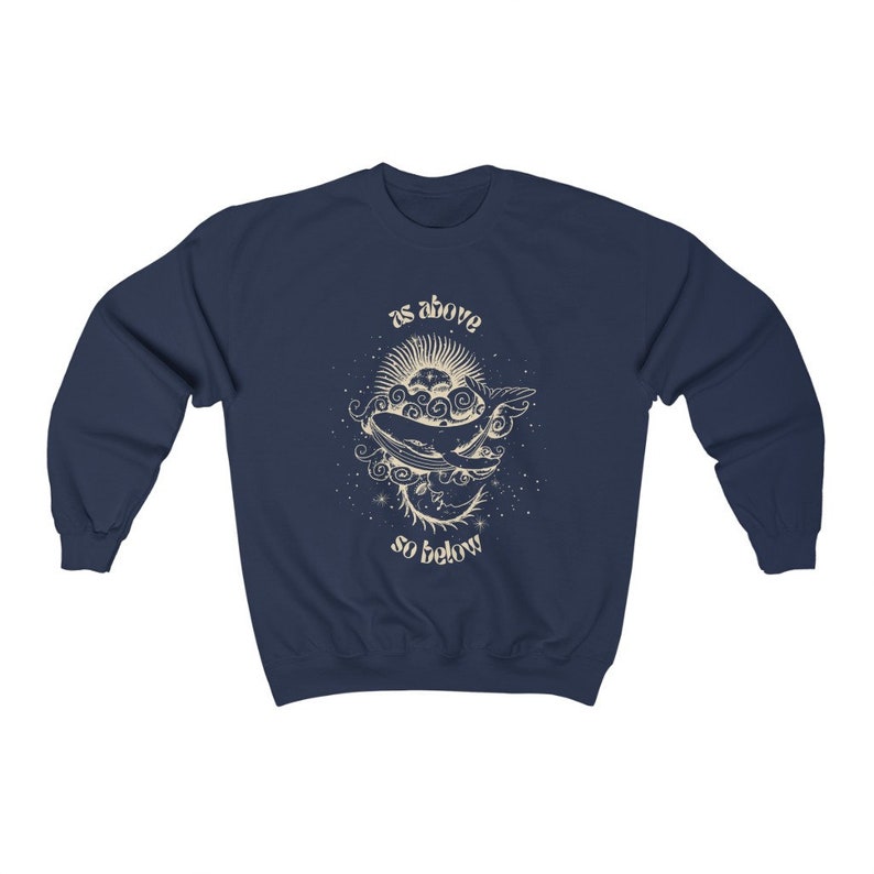 May include: Navy blue sweatshirt with a graphic of a whale swimming through clouds and stars. The text "as above so below" is printed below the whale.