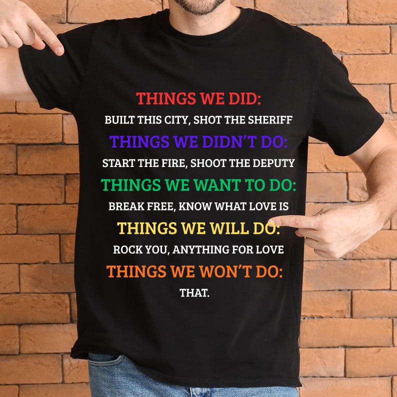 K&ouml;nnte beinhalten: Schwarzes T-Shirt mit farbigem Text, der Dinge auflistet, die getan wurden, nicht getan wurden, gew&uuml;nscht werden und getan werden. Der Text enth&auml;lt S&auml;tze wie "Built this city".