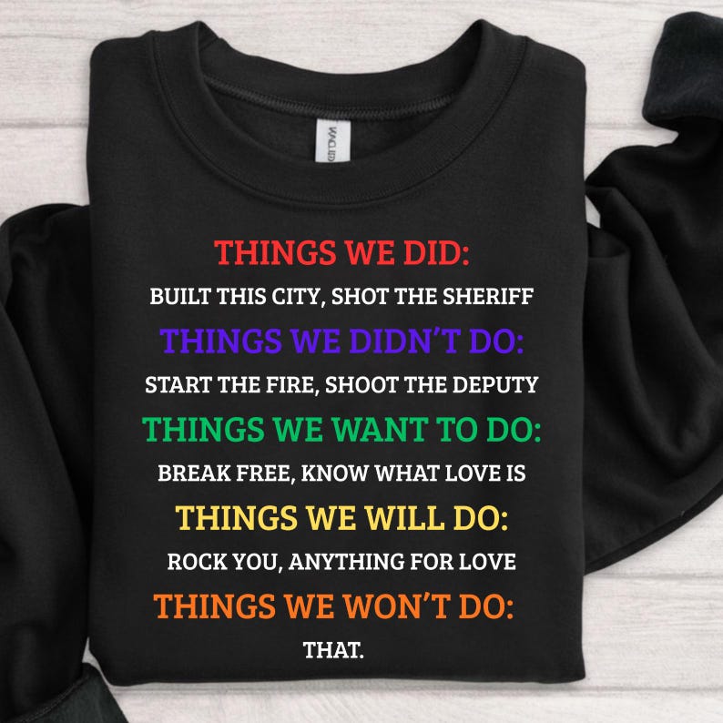 K&ouml;nnte beinhalten: Schwarzes Sweatshirt mit mehrfarbigem Text. Der Text listet Dinge auf, die getan wurden, nicht getan wurden, gewollt sind und kommen werden. Die Farben umfassen Rot, Lila, Gr&uuml;n, Gelb und Orange. Der Text liest sich wie eine Liste von Aussagen.