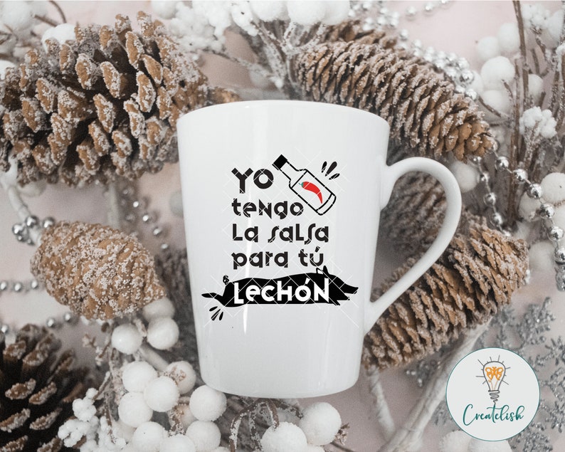 May include: White ceramic mug with a black graphic that says "Yo tengo la salsa para tu lech&oacute;n" with a red chili pepper and a red bottle of hot sauce.