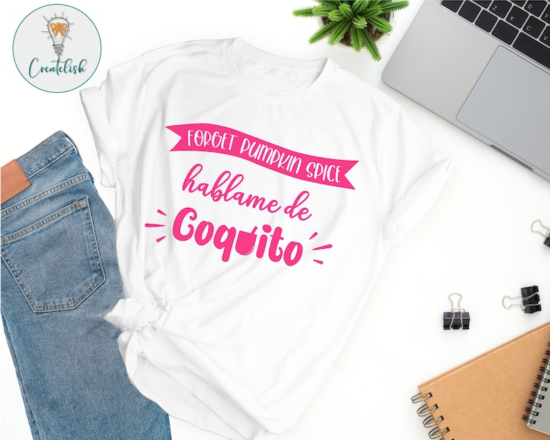 May include: White t-shirt with pink text that reads "Forget pumpkin spice, hablame de Coquito".