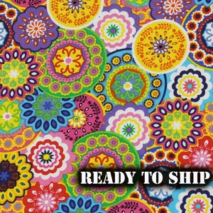 May include: Colorful fabric with a repeating pattern of bright, multi-colored circular designs. The fabric has a paisley-like pattern with a variety of colors including pink, yellow, green, blue, and purple. The text "READY TO SHIP" is printed in white on a black background.